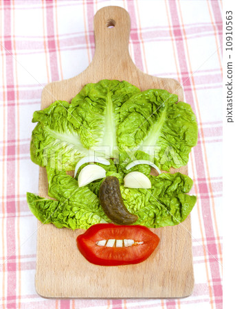 Funny face composition made of vegetables on wooden board. Funny face composition made of vegetables on wooden board. 10910563
