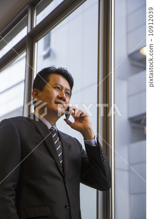 Young Asian businessman with mobile phone Young Asian businessman with mobile phone 10912039