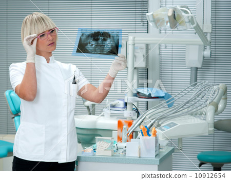 woman dentist looking x-ray image 10912654