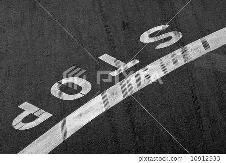 Stop label and line on the asphalt road with braking tracks across it 10912933