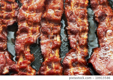 Bacon slice being cooked in frying pan 10913586
