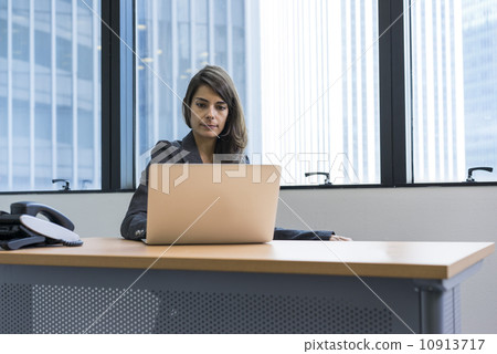 Asian executive in a jacket, working in the office on a laptop 10913717