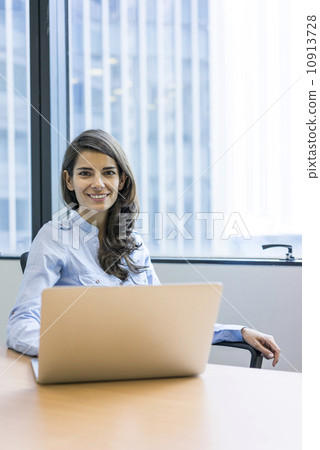 Asian executive working in the office on a laptop 10913728