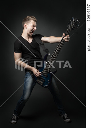 young male musician playing a six-string bass guitar isolated on young male musician playing a six-string bass guitar isolated on 10914367