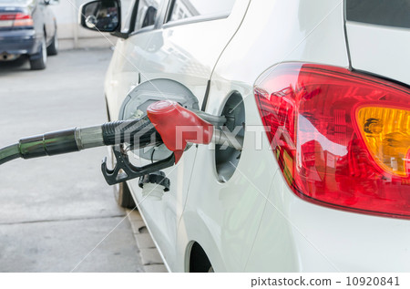 Pumping gas at gas pump 10920841