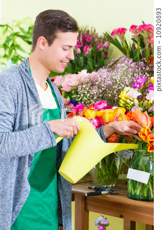 Florist working in flower shop watering plants Florist working in flower shop watering plants 10920893