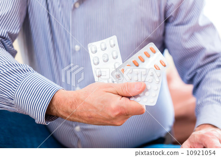 Senior medicate with pills at home 10921054