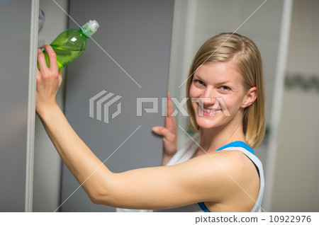Woman putting bottle in locker at healthclub Woman putting bottle in locker at healthclub 10922976