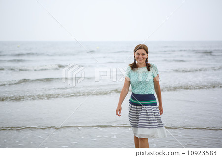 Young happy woman walking on the beach of St.Peter Ording, North 10923583