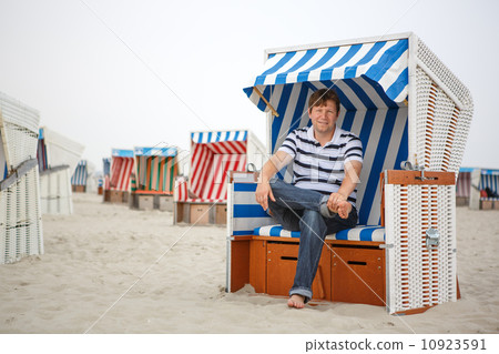 Young happy man on the beach of St.Peter Ording, North Sea, 10923591