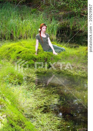 The girl sits on the bank of wood lake The girl sits on the bank of wood lake 10929967