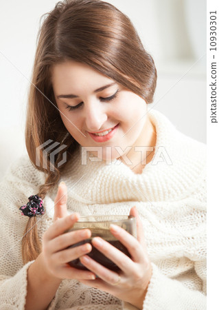 Portrait of brunette woman smiling and holding tea cup Portrait of brunette woman smiling and holding tea cup 10930301