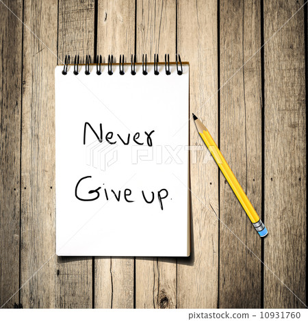 Never give up message on Notebook with pencil on wooden backgrou Never give up message on Notebook with pencil on wooden backgrou 10931760