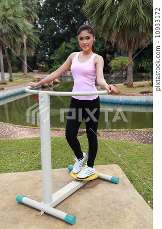 woman exercising with exercise equipment in the park 10933172