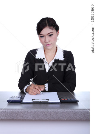 business woman sitting on her desk holding a pen working with do 10933669