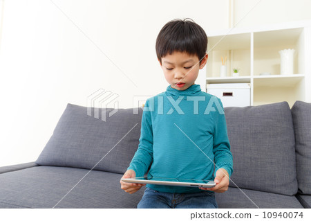 Asia little boy using tablet at home Asia little boy using tablet at home 10940074