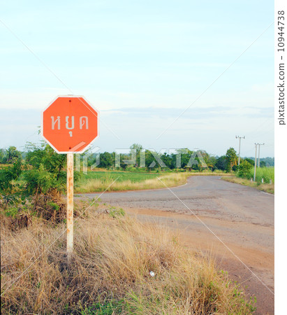 stop sign in a country road (Thai language) 10944738