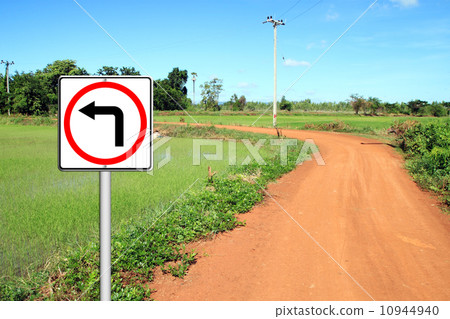 圖庫照片: turn left sign with soil road