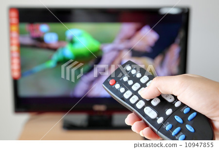 Hand pointing a tv remote control towards the television Hand pointing a tv remote control towards the television 10947855