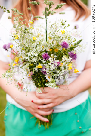 Woman holding wild flowers 10950272