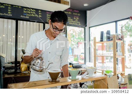 Young waiter making cup of coffee at coffee shop 10958412