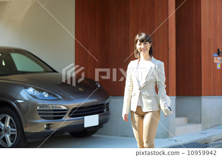 A business woman standing in front of a house A business woman standing in front of a house 10959942