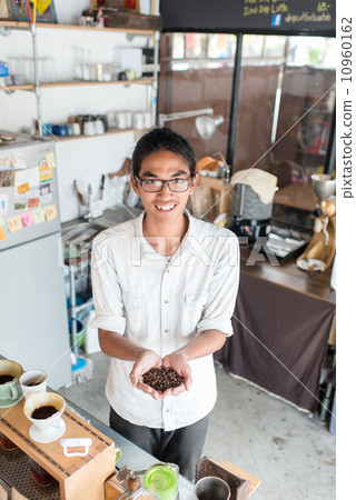 Barista showing coffee beans in his hand. Barista showing coffee beans in his hand. 10960162