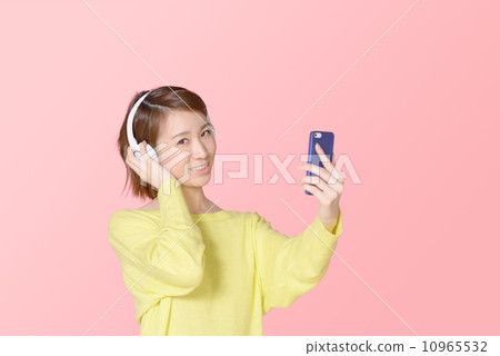 聽到在智能手機的音樂的婦女 10965532