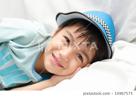 Little boy laying on sofa looking at camera 10967575