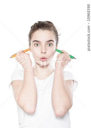 funny teenager girl holding to pens in her ears, isolated on whi 10968390