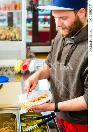 salesman making hotdog in fast food snack bar 10969007