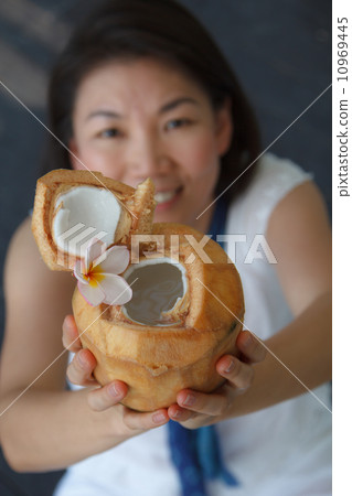 vivacious woman giving a coconut water 10969445