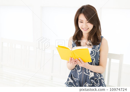 讀一本書的婦女在屋子裡 10974724