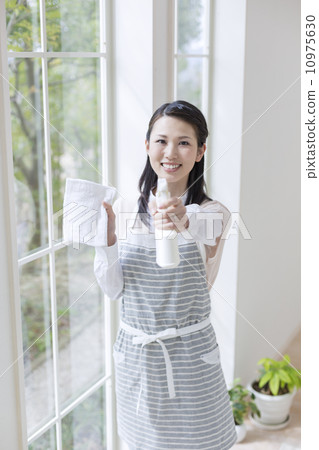 一個女人用布和噴霧 10975630