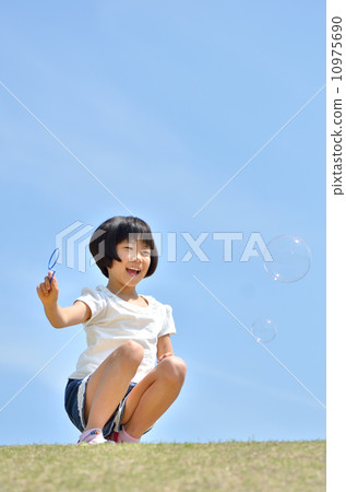 Girl playing soap bubble at lawn open space (blue sky) 10975690