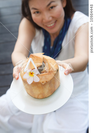 vivacious woman giving a coconut water vivacious woman giving a coconut water 10984448