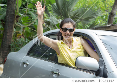 Woman waving in the car Woman waving in the car 10984452