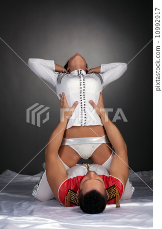 Sexy dancer posing sitting astride her partner 10992917