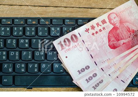 100 Taiwan Dollar bill on keyboard 10994572