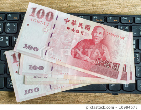 100 Taiwan Dollar bill on keyboard 10994573