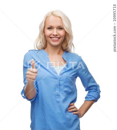 smiling girl in casual clothes showing thumbs up 10995718