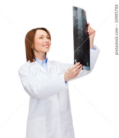 smiling female doctor looking at x-ray smiling female doctor looking at x-ray 10995788