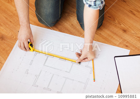 close up of male hands measuring blueprint close up of male hands measuring blueprint 10995881