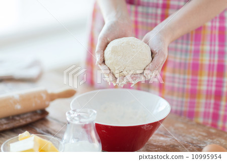 close up of female hands kneading dough at home close up of female hands kneading dough at home 10995954