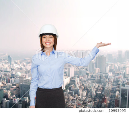 businesswoman in helmet holding something on palm businesswoman in helmet holding something on palm 10995995