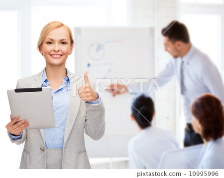 smiling woman with tablet pc showing thumbs up smiling woman with tablet pc showing thumbs up 10995996