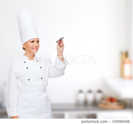 smiling female chef writing something on air smiling female chef writing something on air 10996086