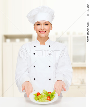 smiling female chef with salad on plate 10996384