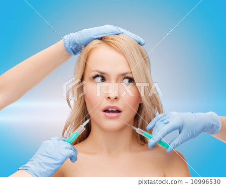 woman face and beautician hands with syringes 10996530