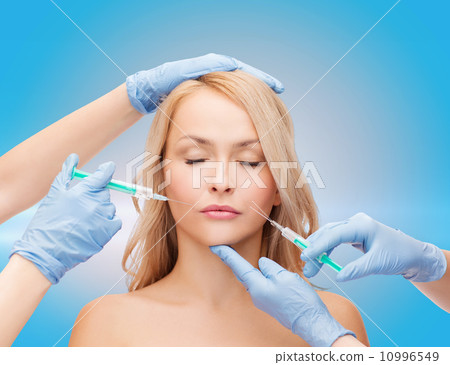 woman face and beautician hands with syringes 10996549